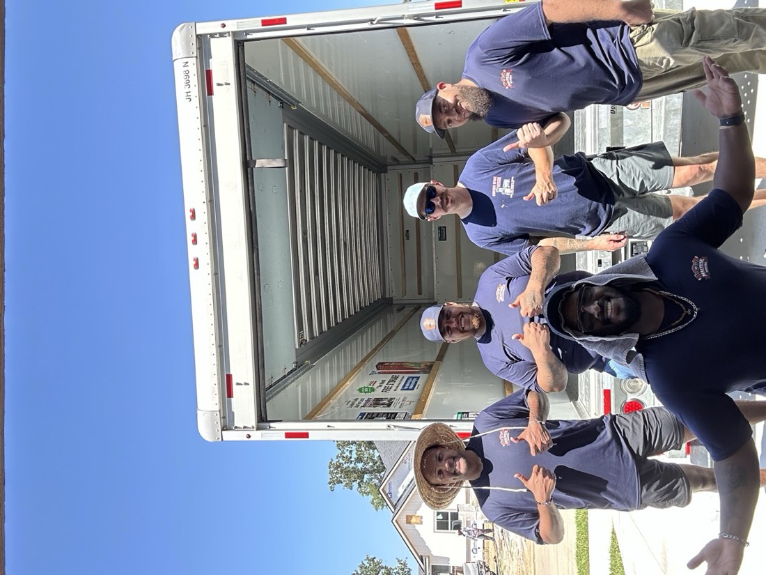 The Maltese Movers crew in front of an empty moving truck after a completed job